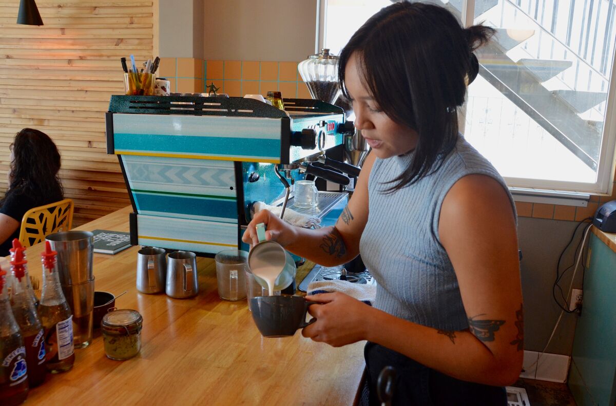 Costa Mesa's Hola Adios Coffeeshop barista CeCe Roque prepares a latte from the  LaMarzocco espresso machine.