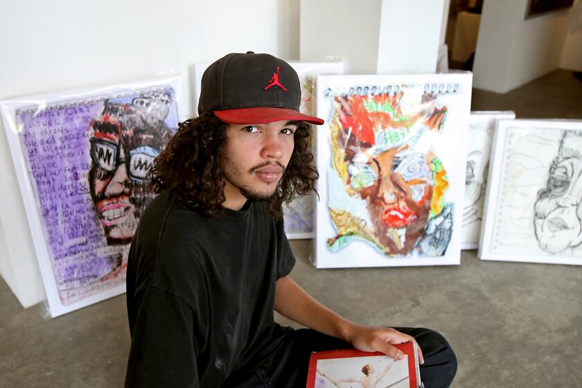 Julian St. John, an artist who has struggled with mental illness, sits among his most notable work that will be showcased at a one-night show at the Laguna Gallery of Contemporary Art.