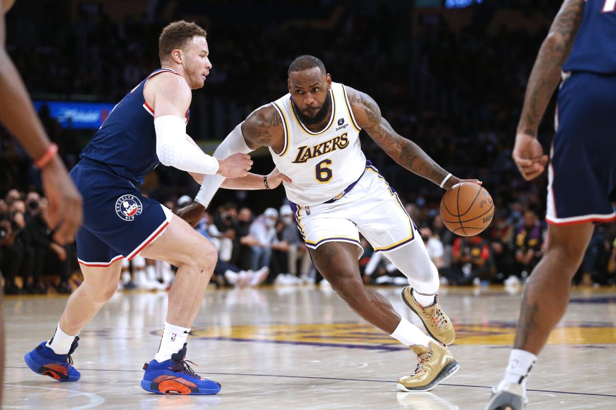 Lakers star LeBron James, right, tries to drive around Brooklyn Nets forward Blake Griffin.