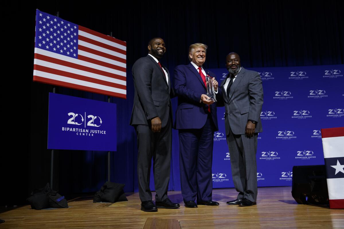President Trump is awarded the Bipartisan Justice Award by Matthew Charles, right, one of the first prisoners released under the First Step Act, during a forum Friday at Benedict College in Columbia, S.C.