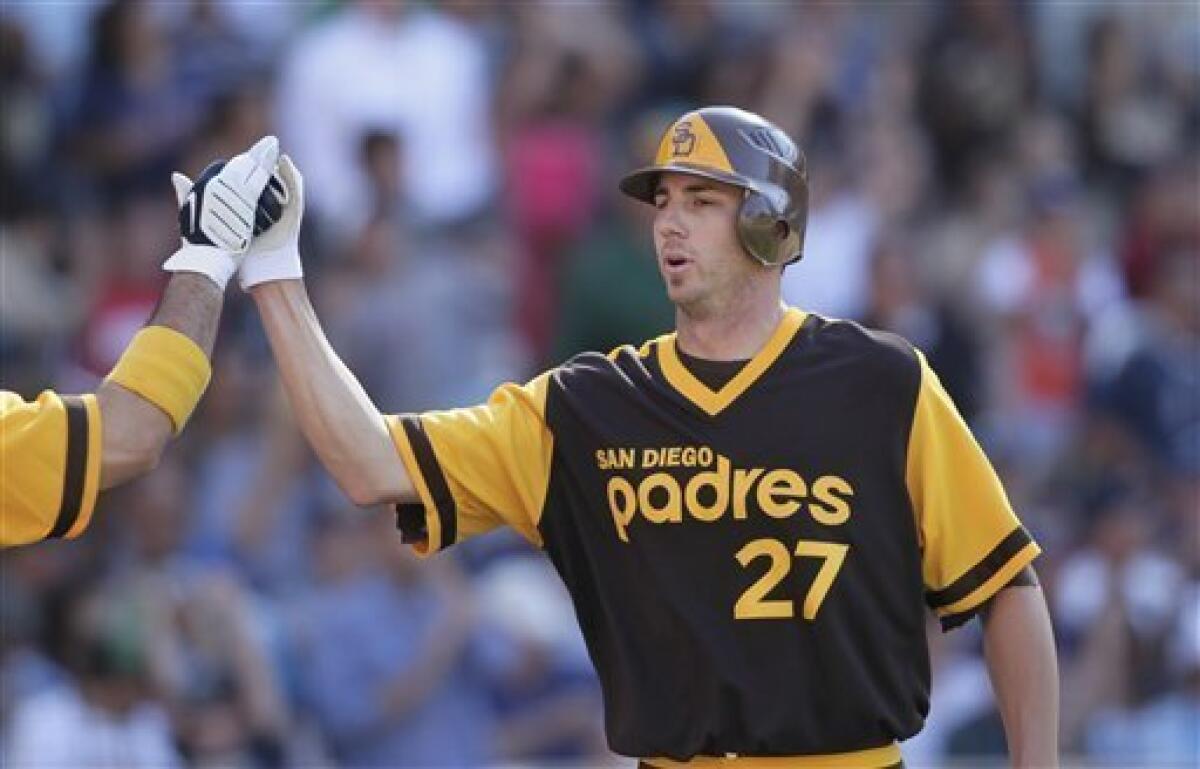 San Diego Padres' Jon Garland is greeted at the plate by Adrian Gonzalez after scoring on a double hit by Miguel Tejada in the third inning during their baseball game Thursday, Aug. 12, 2010 in San Diego. (AP Photo/Gregory Bull)