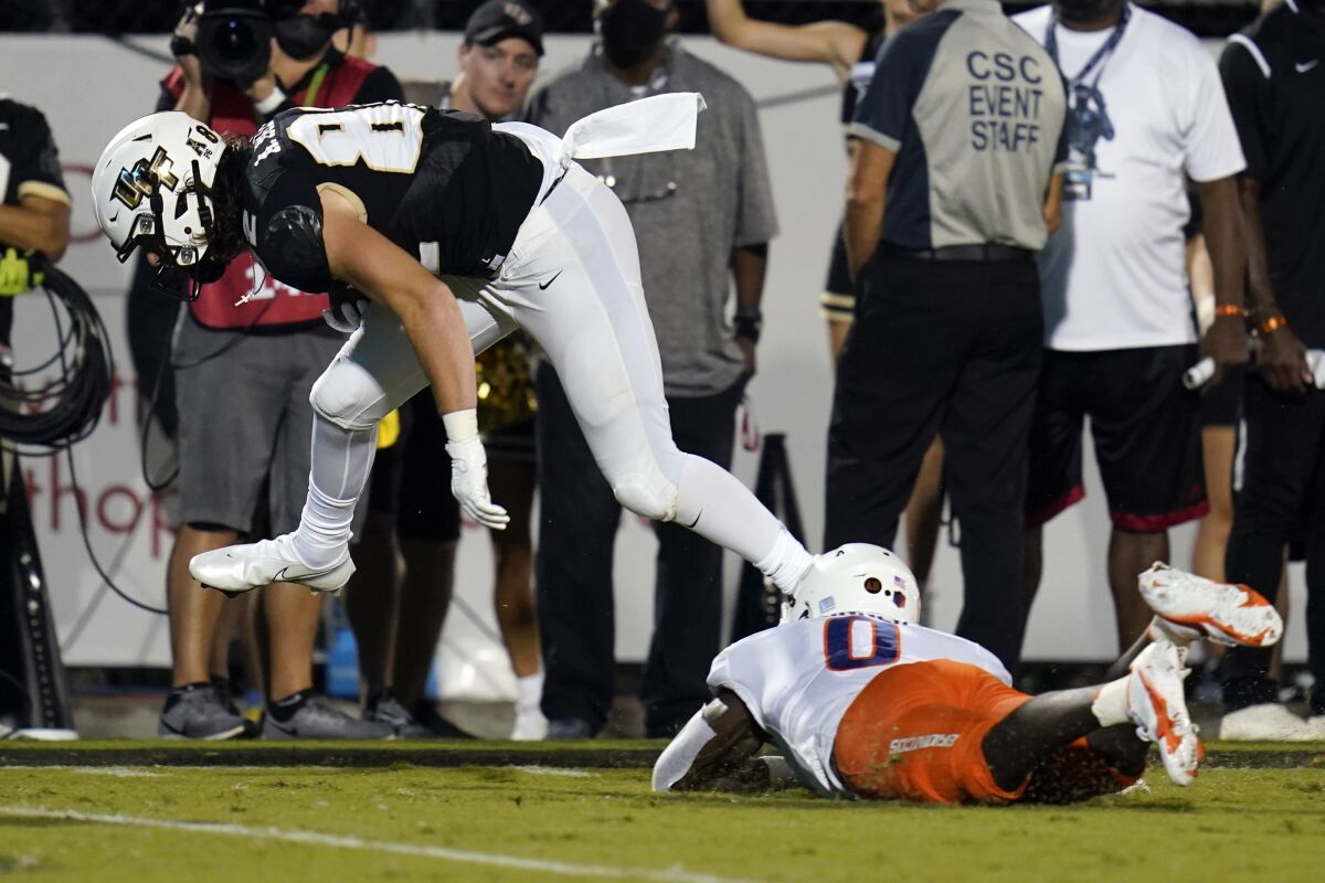 Central Florida tight end Alec Holler leaps over Boise State safety JL Skinner (0) on his way to a 23-yard touchdown reception during the first half of an NCAA college football game Thursday, Sept. 2, 2021, in Orlando, Fla. (AP Photo/John Raoux)