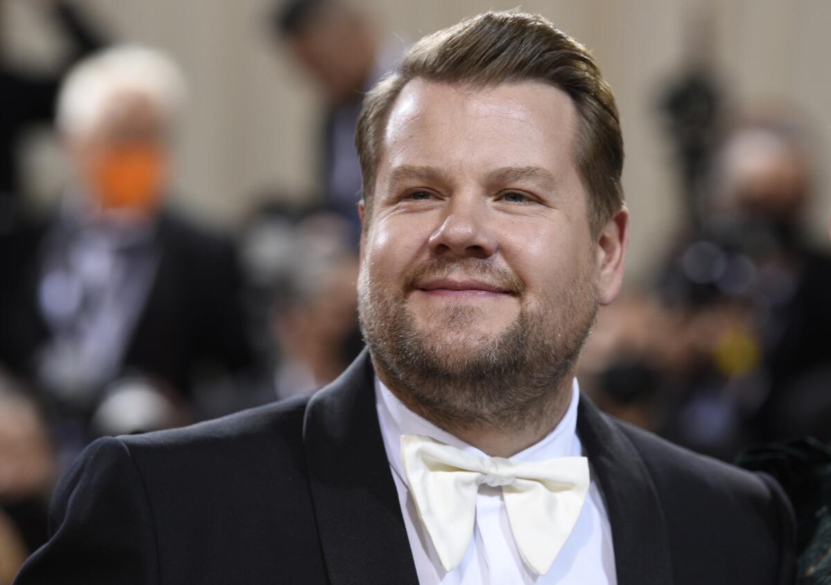 A man smiling in a tuxedo with a white bowtie