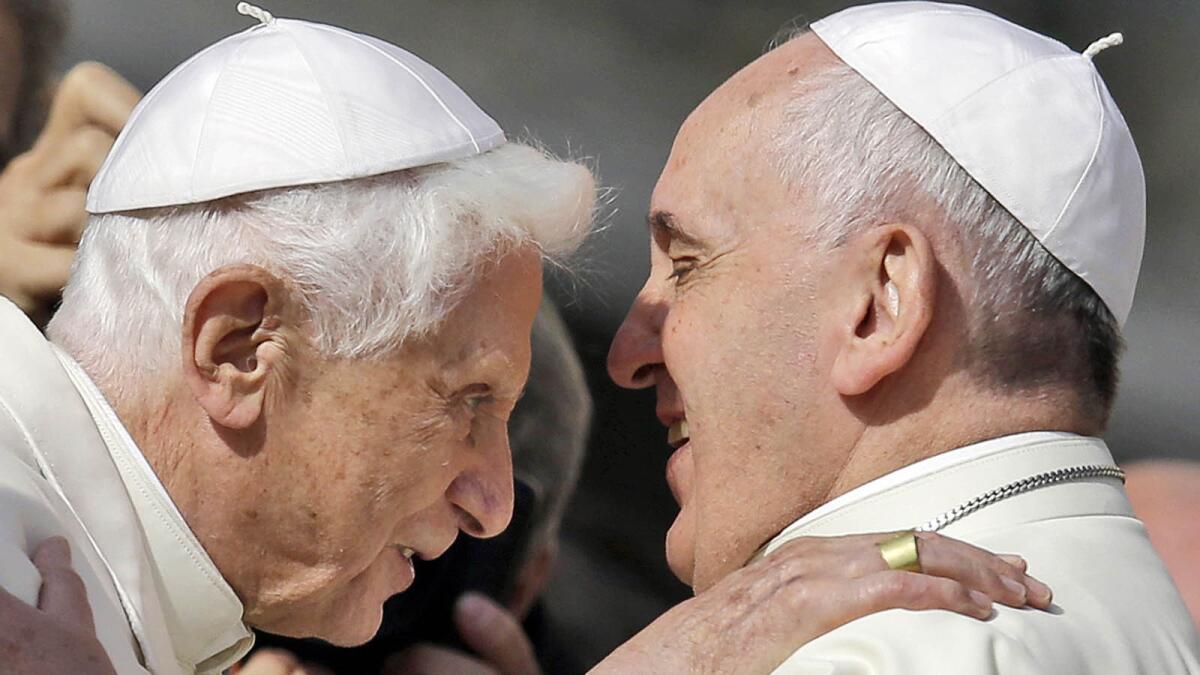 Pope Francis, right, hugs Pope Emeritus Benedict XVI before a meeting with elderly faithful in St. Peter's Square at the Vatican.
