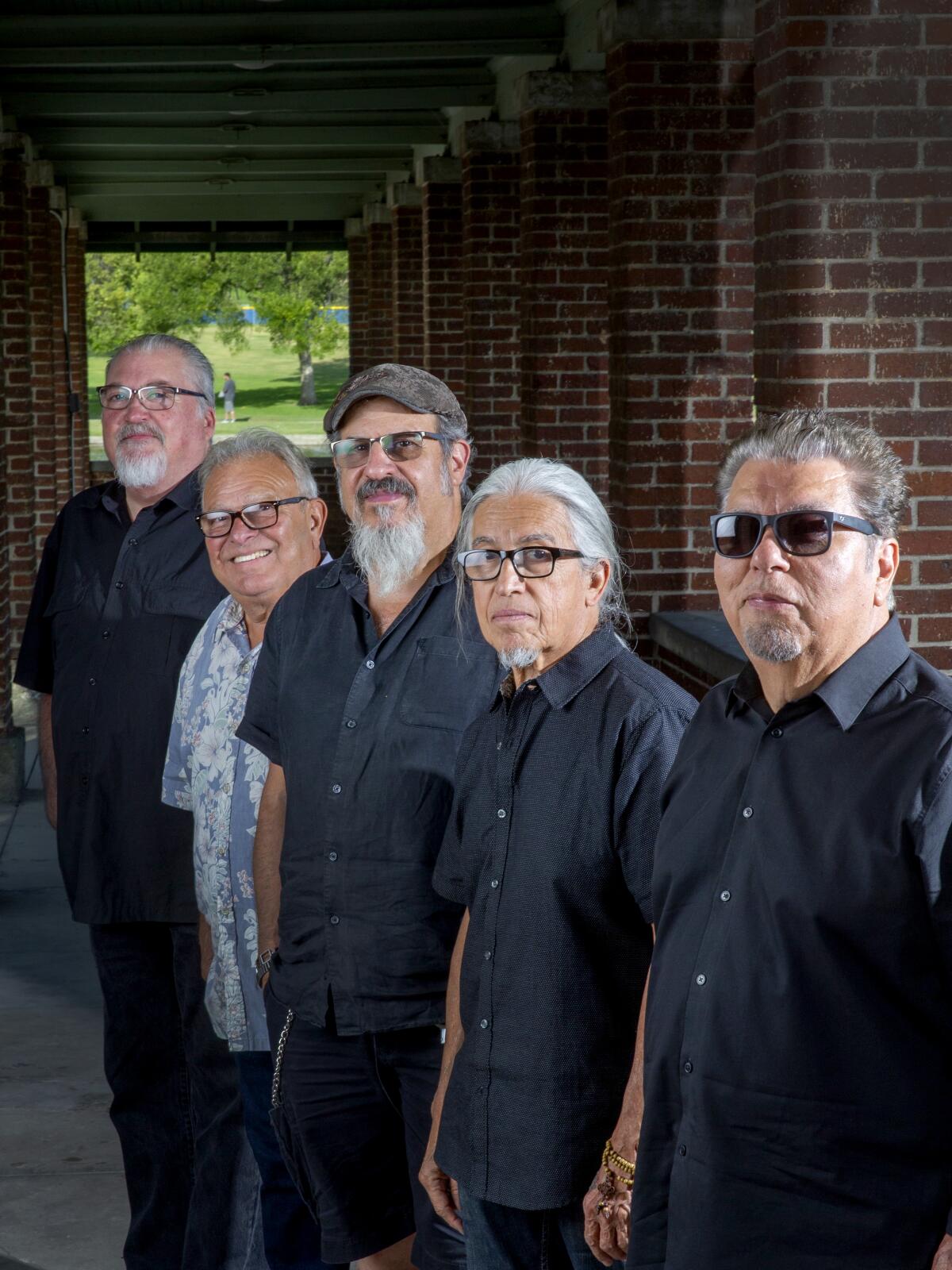 Los Lobos: David Hidalgo, Conrad Lozano, Steve Berlin, Louie Perez,  and Cesar Rosas photographed at Plaza de la Raza 