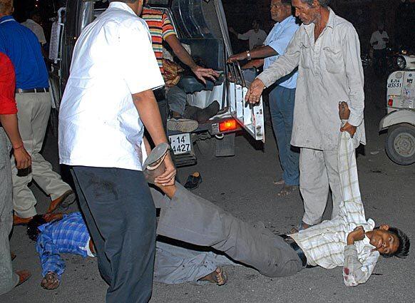 People carry the bodies of two men injured by the blasts to a van. The series of explosions killed at least 60 people and injured scores of others, triggering panic in busy market areas in one of India's most popular tourist cities.