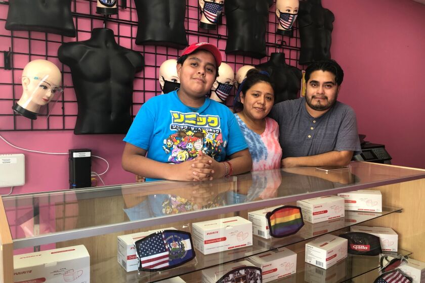 Brandon, a la izquierda, acompaña a sus padres Yolanda Escobar y Luis Villagrán, creadores de la empresa 502 Graphics.