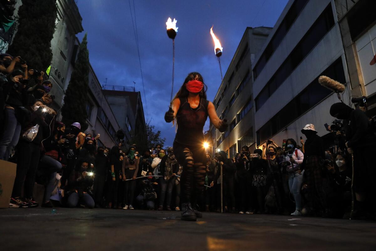 Una mujer hace una demostración con fuego durante una manifestación "antigrito" de feministas