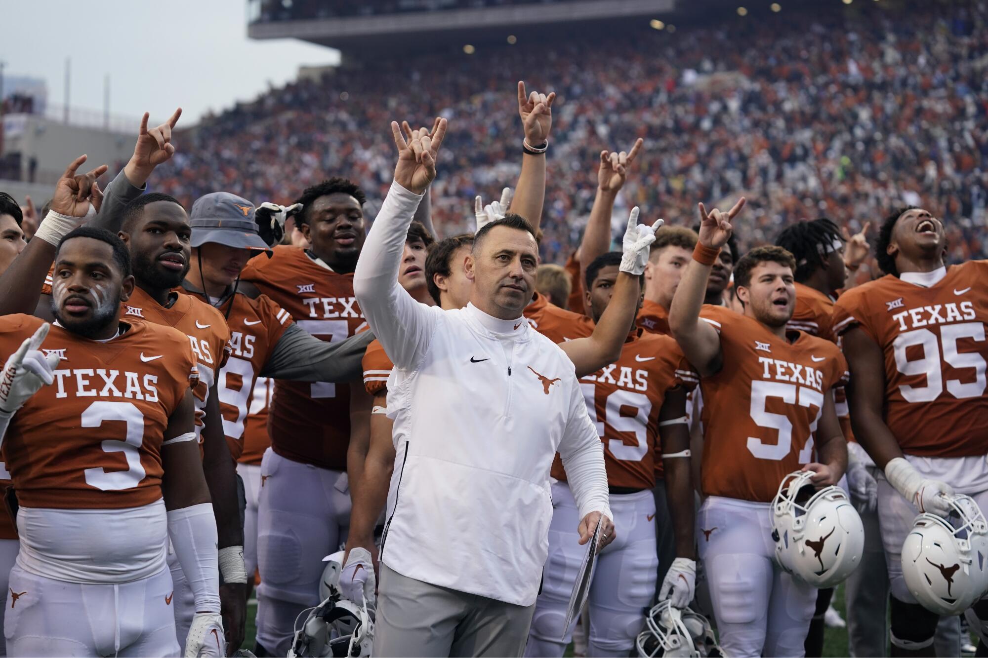 L'entraîneur du Texas Steve Sarkisian, au centre, rejoint son équipe pour la chanson de l'école après une victoire contre Baylor en novembre.