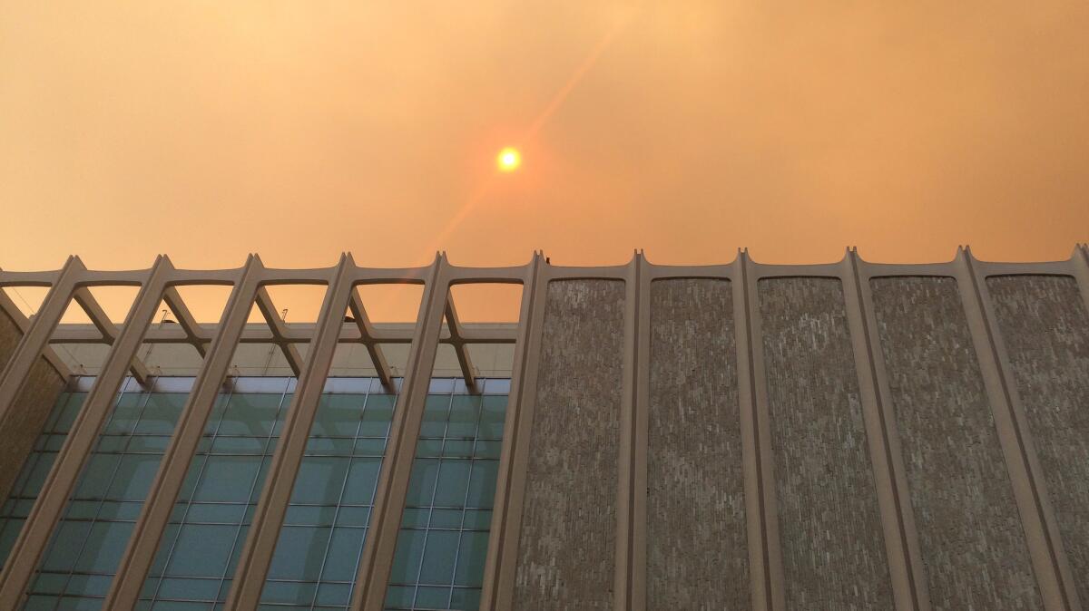 A bleary sun peeks through the smoke over the L.A. County Museum of Art on Saturday.