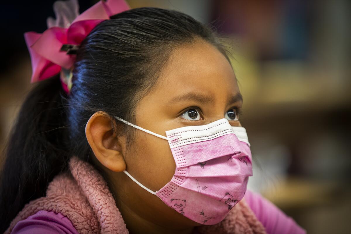 A young student wears a pink mask with a panda print