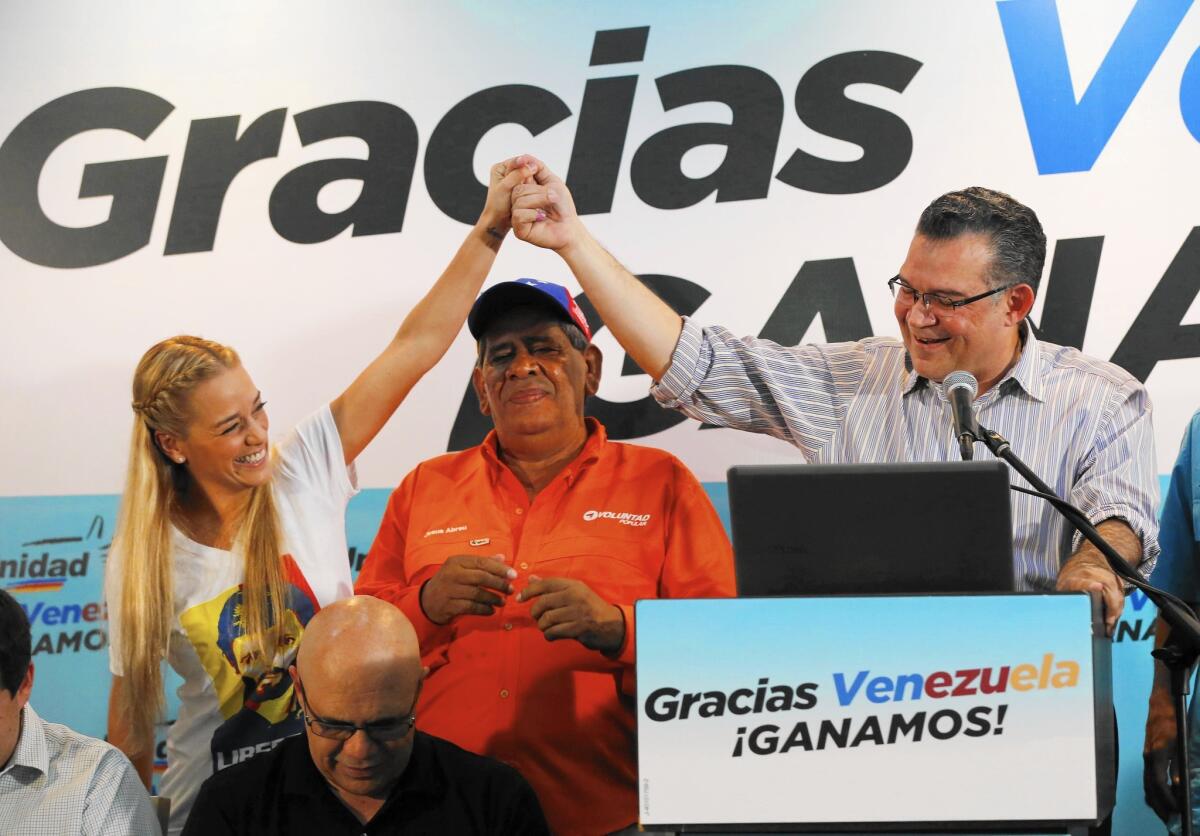 Lilian Tintori, wife of jailed opposition leader Leopoldo Lopez, joins reelected opposition lawmaker Enrique Marquez at a news conference in Caracas, Venezuela.