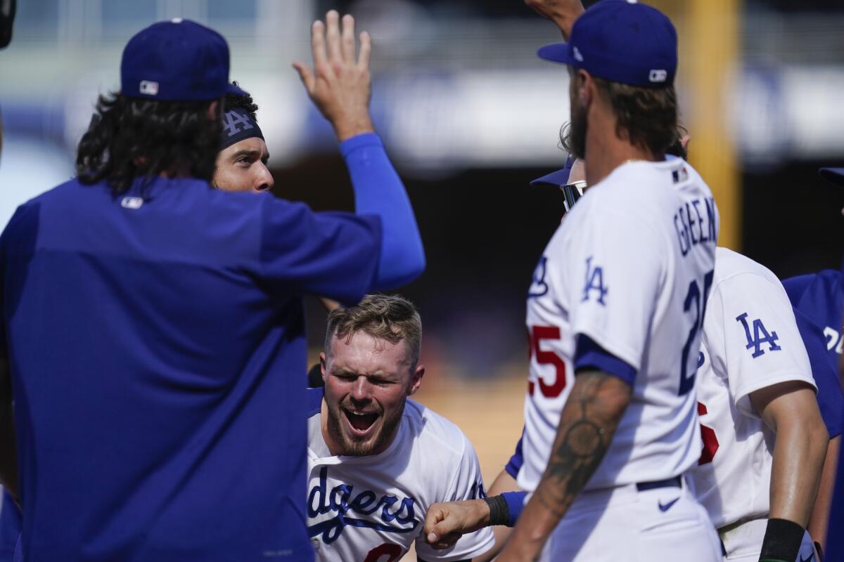 Gavin Lux, center, celebrates with teammates after hitting a walk-off, two-run double in a 5-4 win.