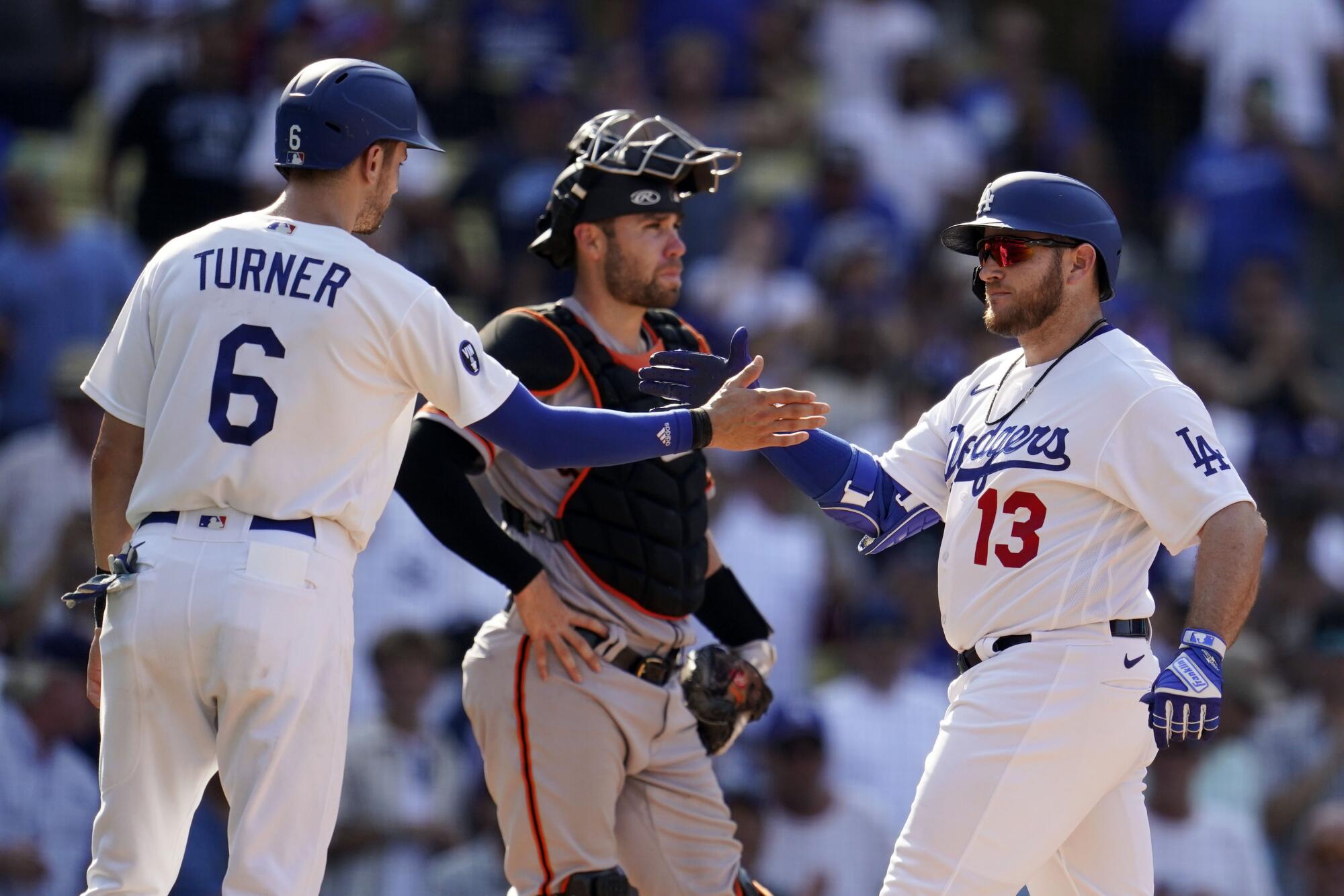 Max Muncy is greeted at home plate by Trea Turner after his three-run home run.