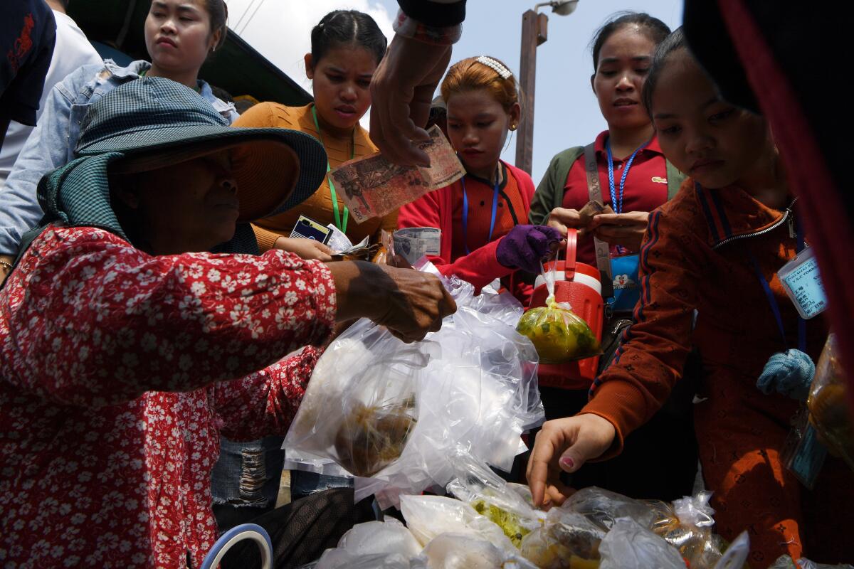 Cambodian workers buy food in front of their factory in Phnom Penh on March 2, 2020.
