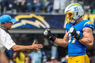 Chargers coach Jim Harbaugh congratulates linebacker Joey Bosa (97) after a drive-ending sack against the Las Vegas Raiders.