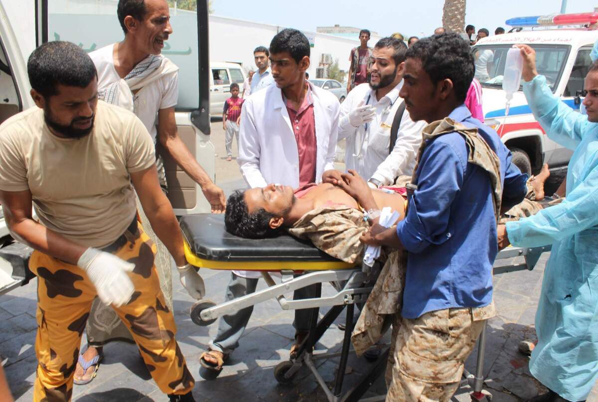 Yemeni emergency personnel carry an injured man on a stretcher following twin bombings that targeted Yemeni forces in the southern city of Aden on May 23, 2016.