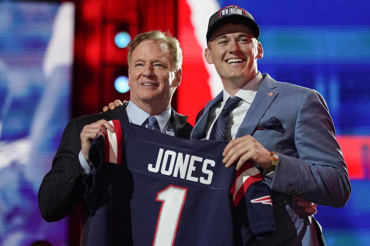 Alabama quarterback Mac Jones holds a Patriots jersey with NFL commissioner Roger Goodell.