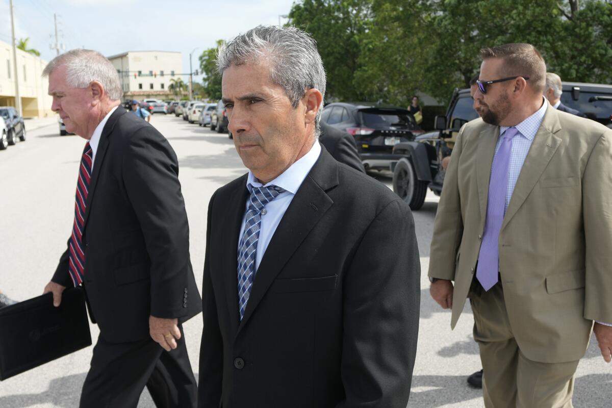 Carlos De Oliveira leaves court with two other men.