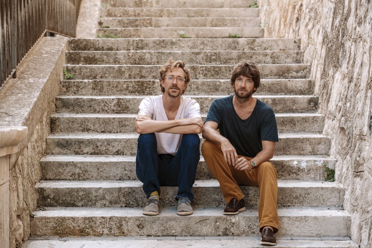This photo provided by Salvo Alibrío shows Norwegian indie duo Kings of Convenience, Eirik Glambek Bøe, right, and Erlend Øye at the medieval castle of Palazzolo Acreide in Sicily, Italy, in September 2020. Largely quiet since the release of their last album, the band recently broke their silence with “Peace Or Love,” Erlend Øye and Eirik Glambek Bøe’s first album together in 12 years. (Salvo Alibrío via AP)