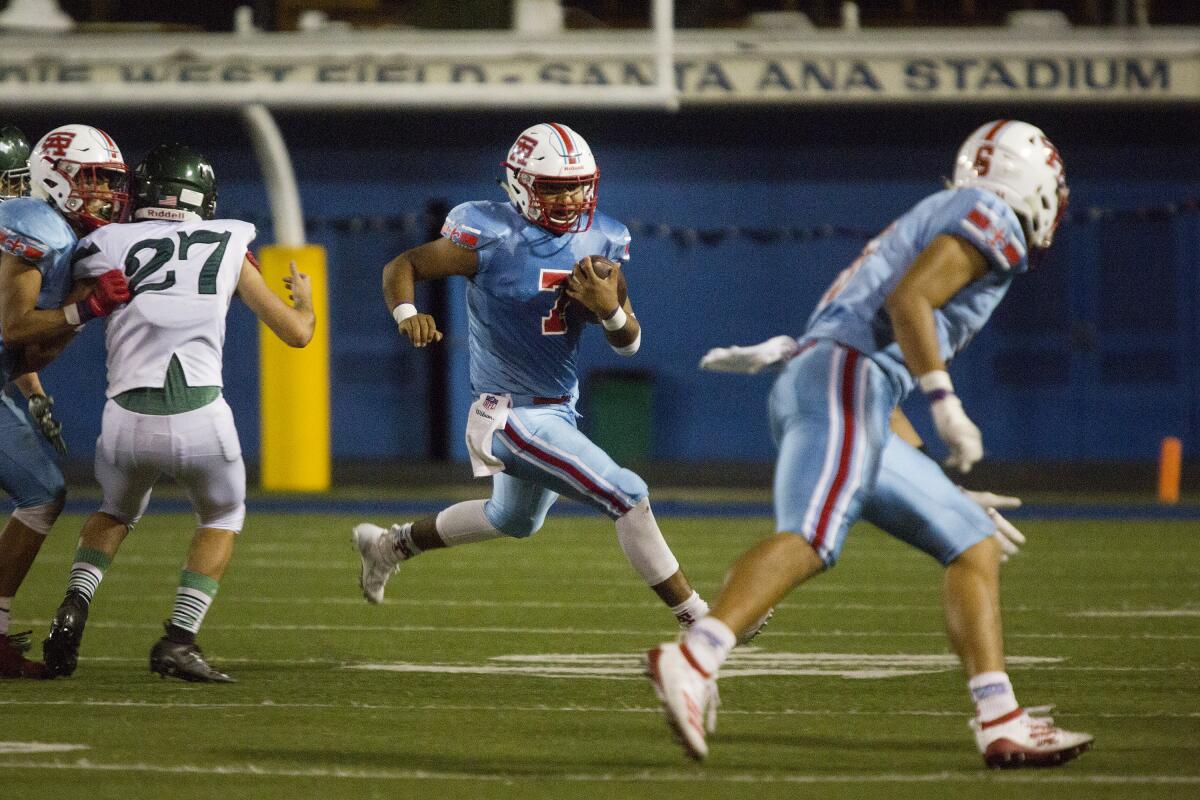 Santa Ana quarterback Aldo Leyva runs the ball for a short gain against Costa Mesa in an Orange Coast League opener at Santa Ana Stadium on Thursday.