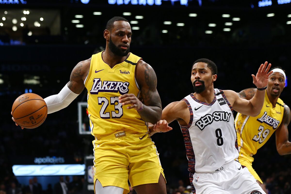 Lakers forward LeBron James drives again Nets guard Spencer Dinwiddie as center Dwight Howard (39) cuts to the basket during a game on Jan. 23, 2020, at Barclays Center in Brooklyn.