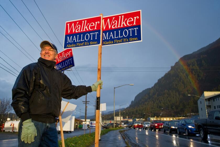 Byron Mallott, a candidate for Alaska lieutenant governor, waves a sign in Juneau on election day. Mallott's running mate is Bill Walker, who narrowly leads Gov. Sean Parnell.