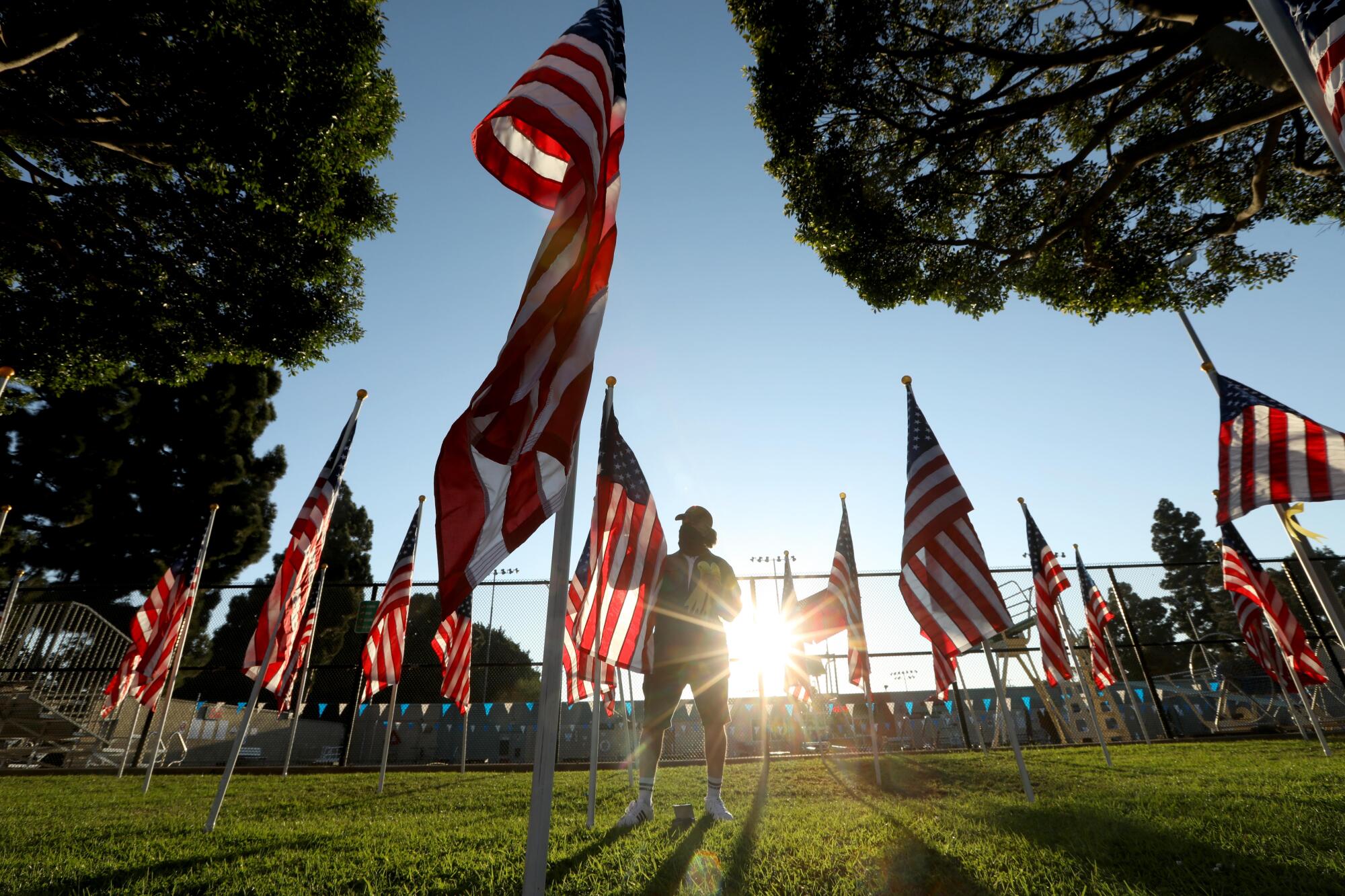 Jeff Cooper, president of Culver City Exchange, places a ribbon on each flag with the name of a veteran.