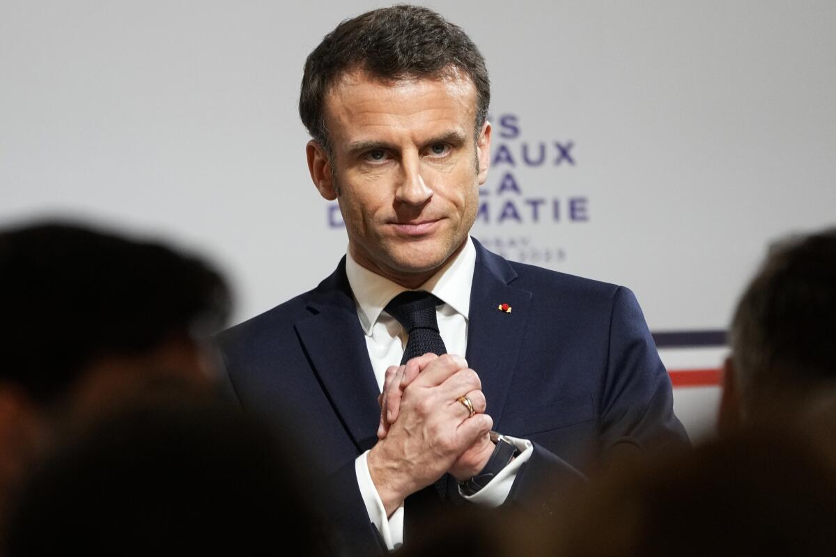 French President Emmanuel Macron clasping his hands
