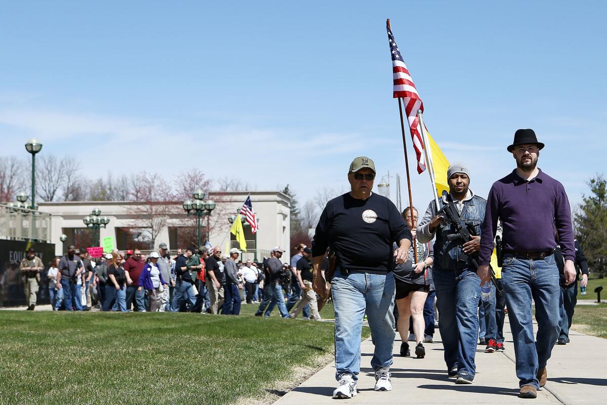 Gun owners and supporters march along Allegan Street in downtown Lansing, Mich., during an open carry gun rally and march on April 29.