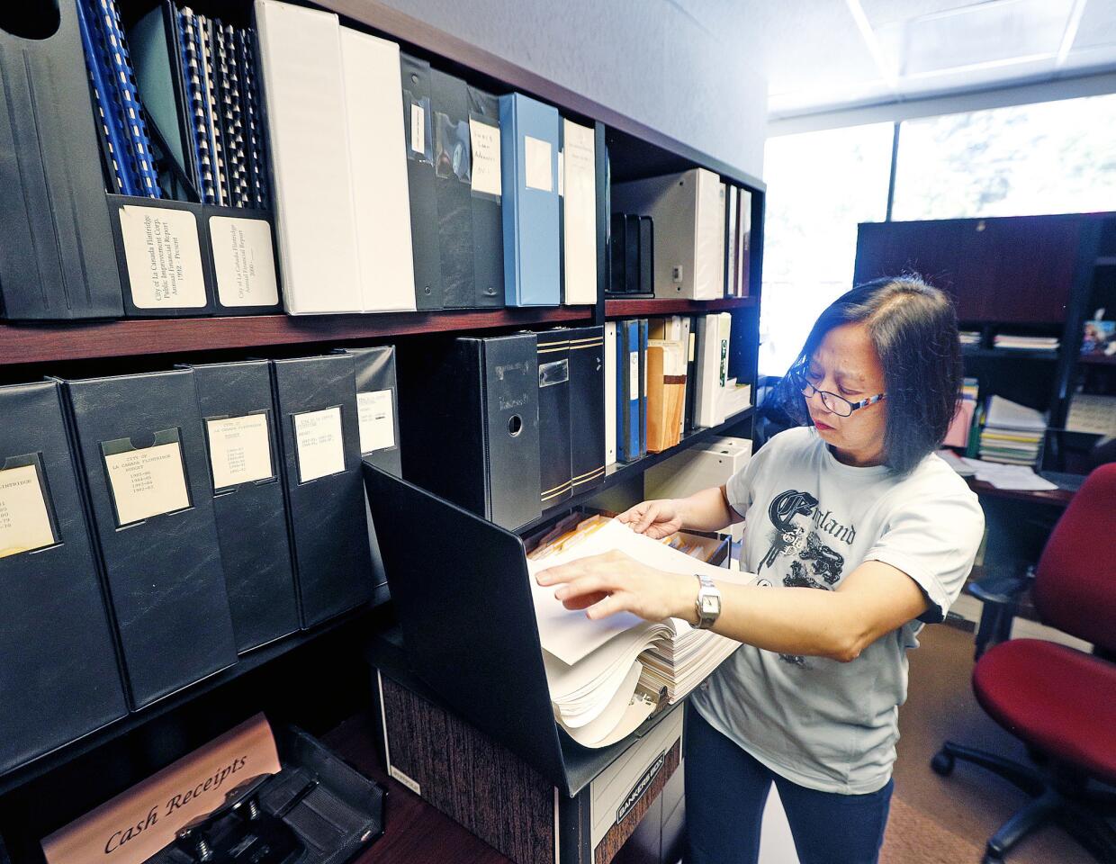Senior Accountant Winnie Fung scans through files, looking for when the city purchased the building on the third Friday of seven to pack desks and files at La Canada City Hall on Friday, August 3, 2018. The official move isn't until December, but over these seven weeks, all of the departments are taking advantage of the slowness of summer and that the weather isn't wet to get a lot done.