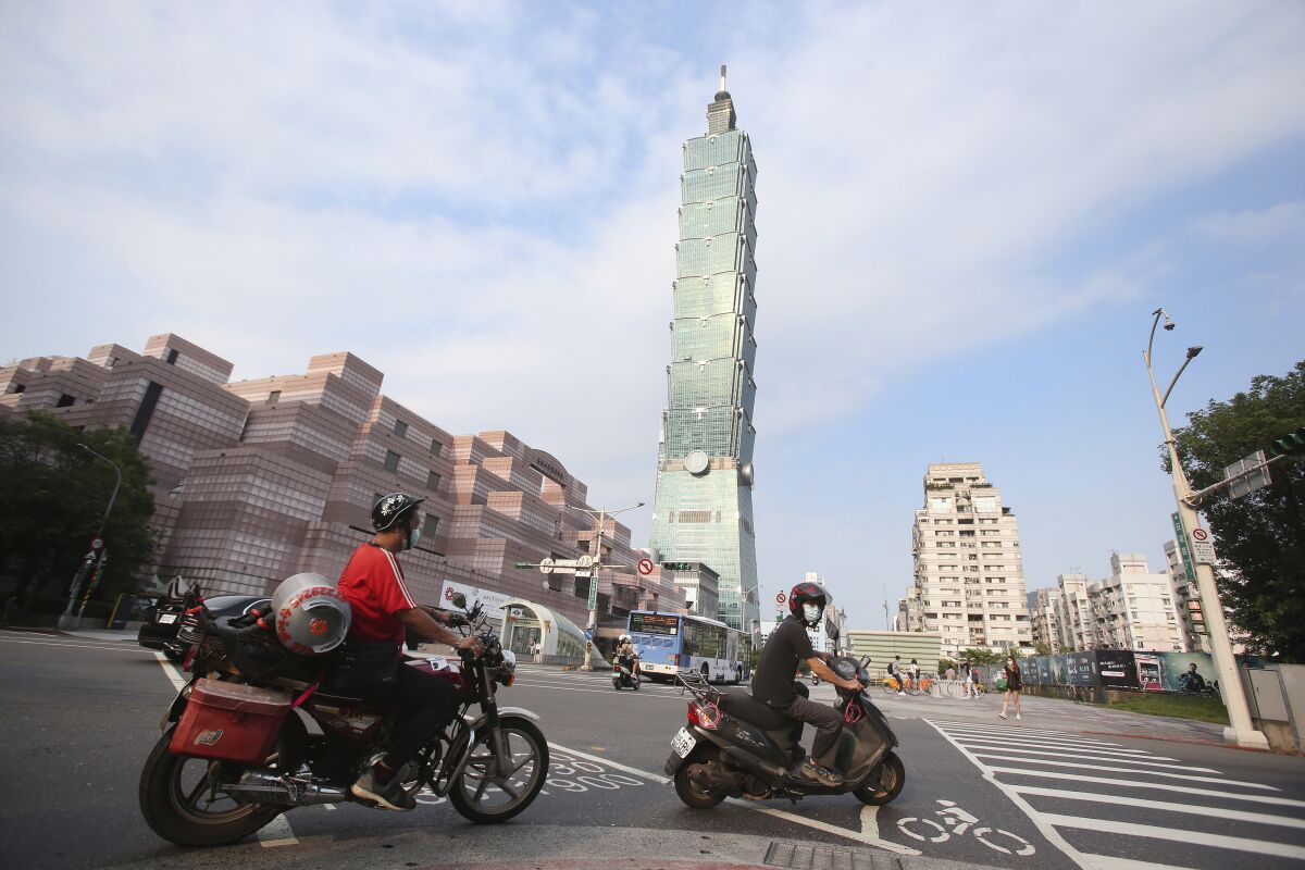 FILE - People ride past Taipei 101 building in Taipei, Taiwan, Saturday, May 15, 2021. A strong earthquake struck off the east coast of Taiwan on Monday, shaking buildings in the capital, Taipei. No serious damage or injuries were reported, and authorities said there was no danger of a tsunami. (AP Photo/Chiang Ying-ying, File)