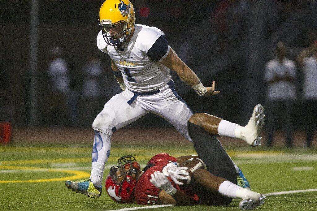 Marina High's Rand Keidel, top, reacts after he made a tackle on Westminster's Isayah Anderson.