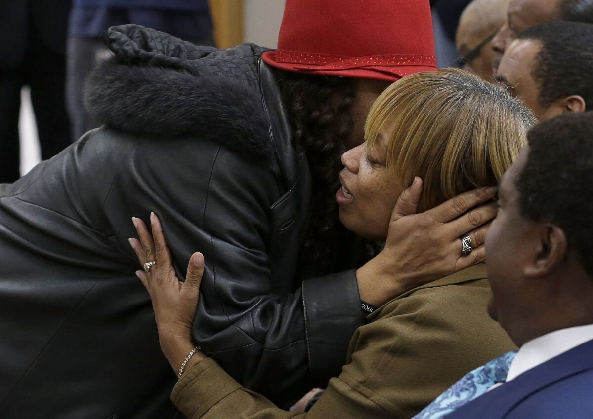 Gwendolyn Woods, right, hugs a friend before a news conference in San Francisco. Her son, Mario, was shot and killed by San Francisco police last month.