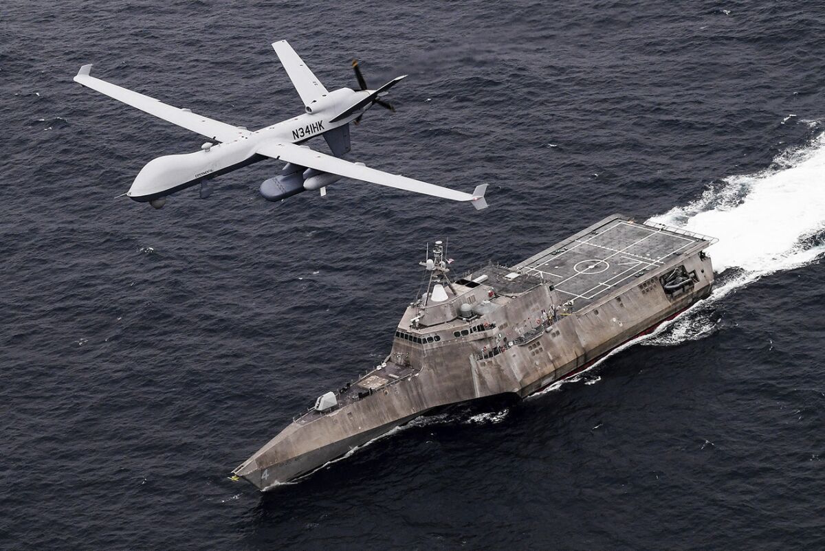In this handout image from the U.S. Navy, an MQ-9 Sea Guardian unmanned maritime surveillance drone flies over the USS Coronado in the Pacific Ocean during a drill April 21, 2021. The U.S. Navy's Mideast-based 5th Fleet said Wednesday, Sept. 8, 2021, it will launch a new task force that incorporates airborne, sailing and underwater drones after years of maritime attacks linked to ongoing tensions with Iran. (U.S. Navy/Chief Mass Communication Specialist Shannon Renfroe, via AP)