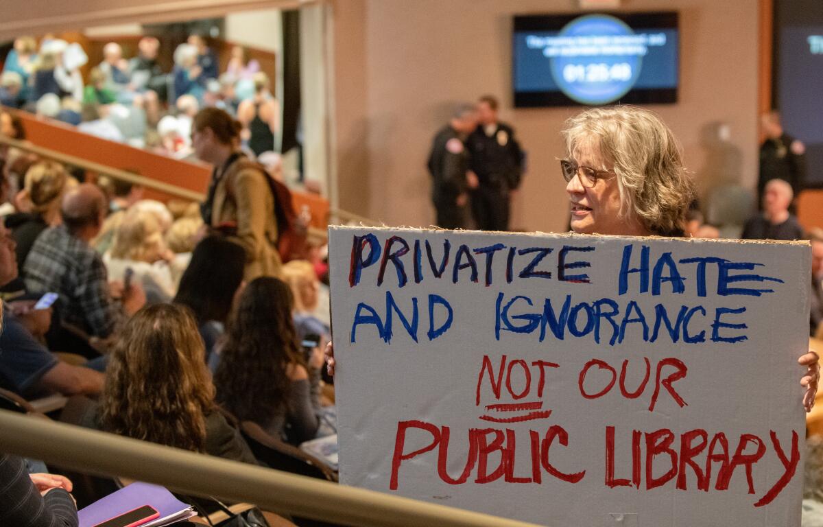 A woman who came out against privatizing Huntington Beach's libraries attends the May 7 City Council meeting.