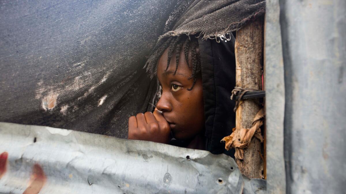 A girl watches as the authorities arrive to evacuate people from her house in Tabarre, Haiti, in advance of Hurricane Matthew.