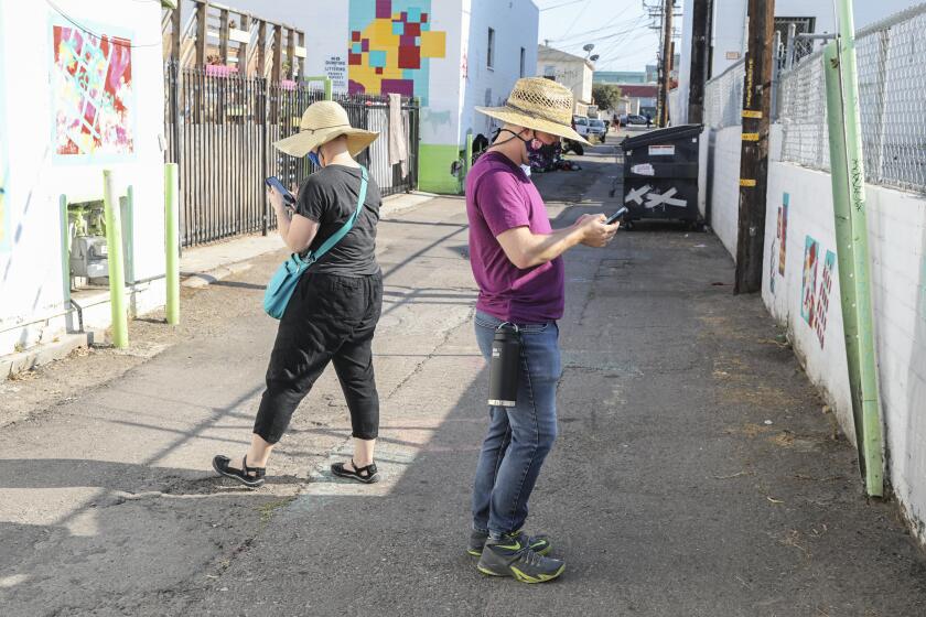 SAN DIEGO, CA - AUGUST 25: James Lively (right) and Lydia Bringerud (left), report graffiti in a alley with the Get it Done app while along Fairmont Ave. and El Cajon Blvd. in City Heights on Tuesday, Aug. 25, 2020 in San Diego, CA. (Eduardo Contreras / The San Diego Union-Tribune)