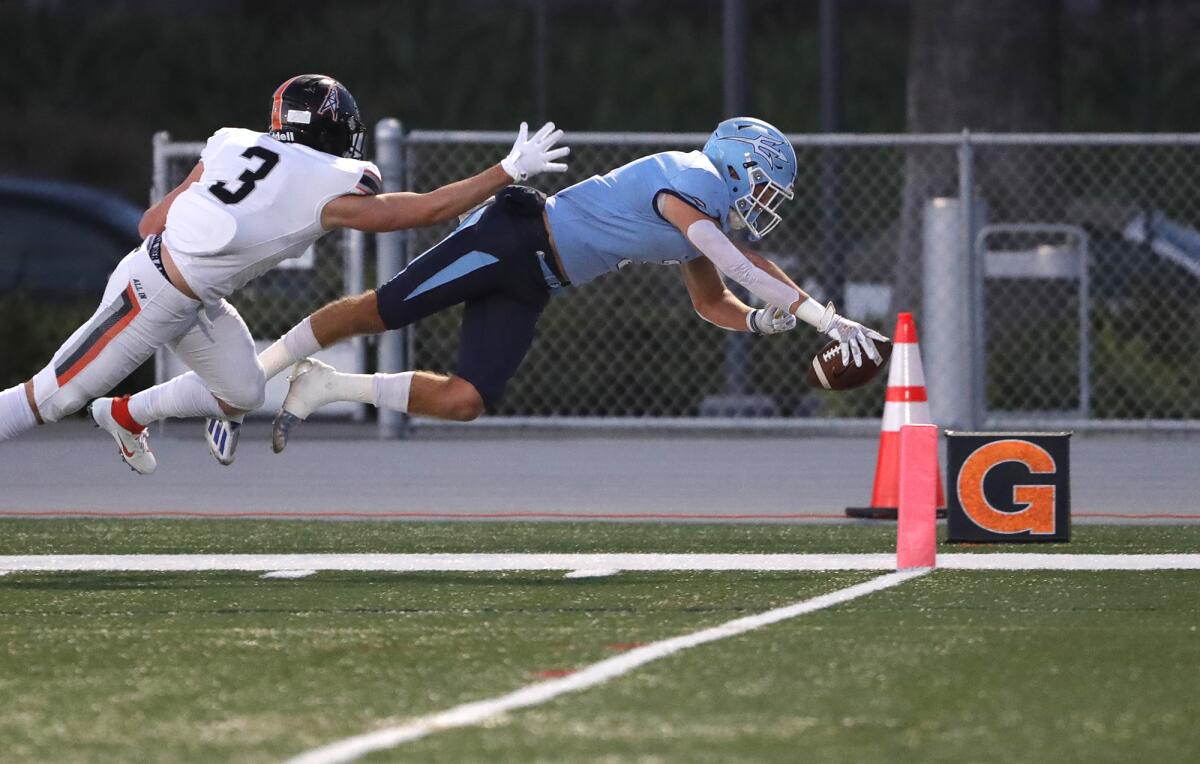 Corona del Mar's Tommy Griffin (3) dives for the end zone against Huntington Beach on Friday.