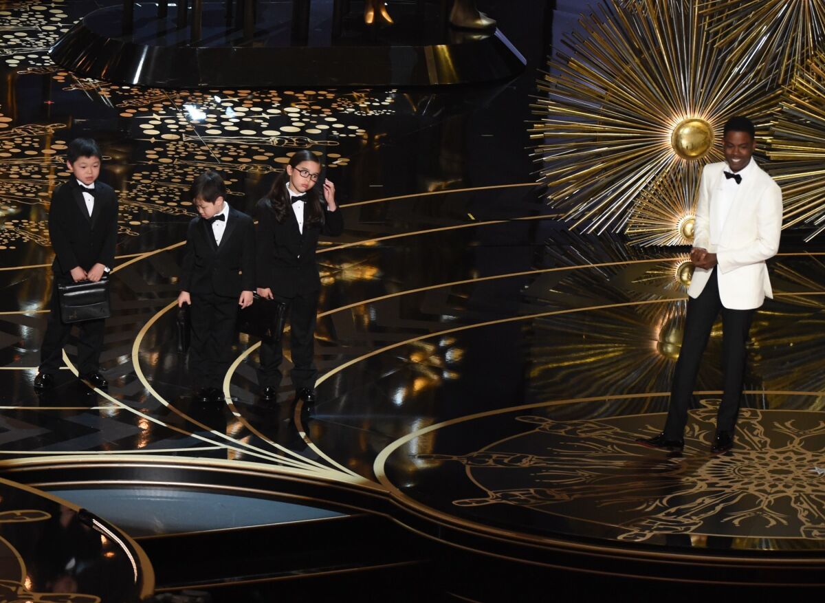 Actor Chris Rock introduces children representing PricewaterhouseCoopers accountants at the 88th Oscars on Sunday.