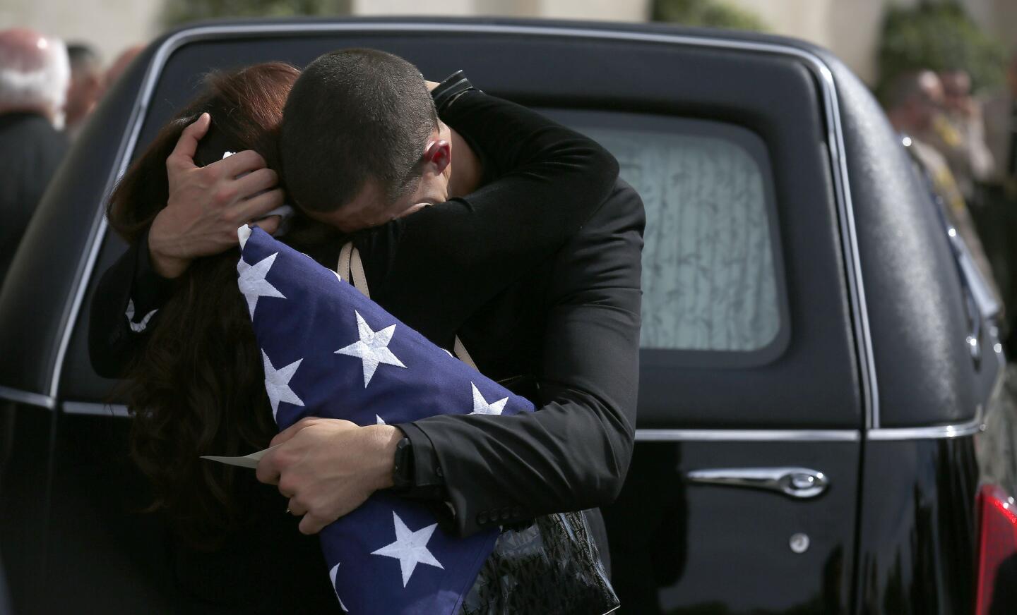 Branden Owen, right, hugs his mother Jennifer outside his father Steve Owen's hearse after the memorial service at Lancaster Baptist Church in Lancaster.