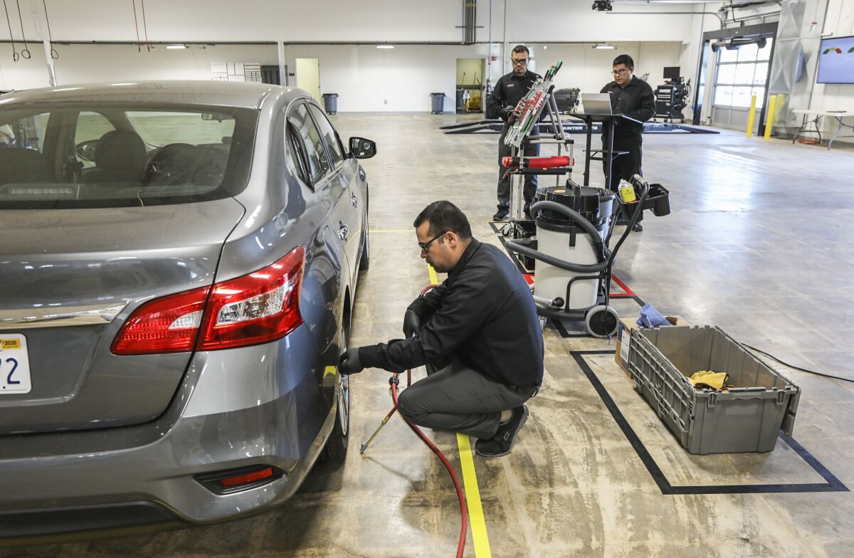 Technician Miguel Gomez checks tire pressure for a vehicle at the Lyft Driver Center.