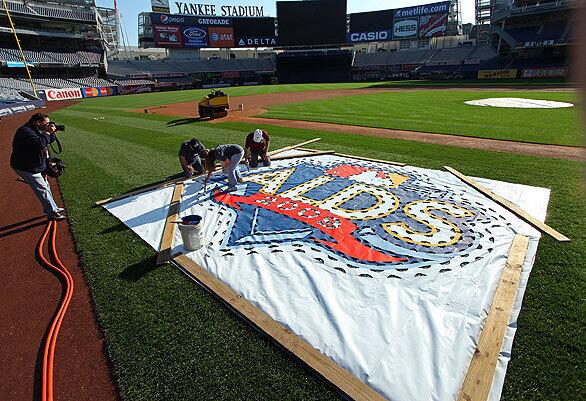 Workers paint the American League Division Series logo on the field at Yankee Stadium in preparation for Game 1 on Wednesday.