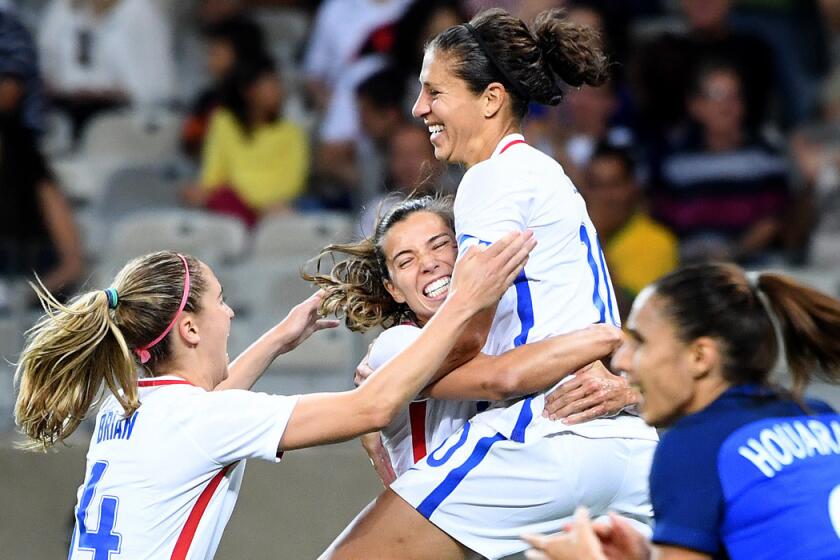 Carli Lloyd jumps into the arms of U.S. teammate Heath Tobin after scoring a goal against France during the 2016 Rio Olympics.