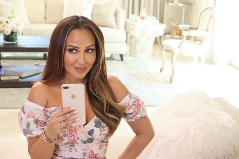 Influencer Adrienne Houghton self-films herself at her home for her show "All Things Adrienne" on YouTube. Before L.A. County required residents to shelter in place, Houghton's show was filmed by a crew.