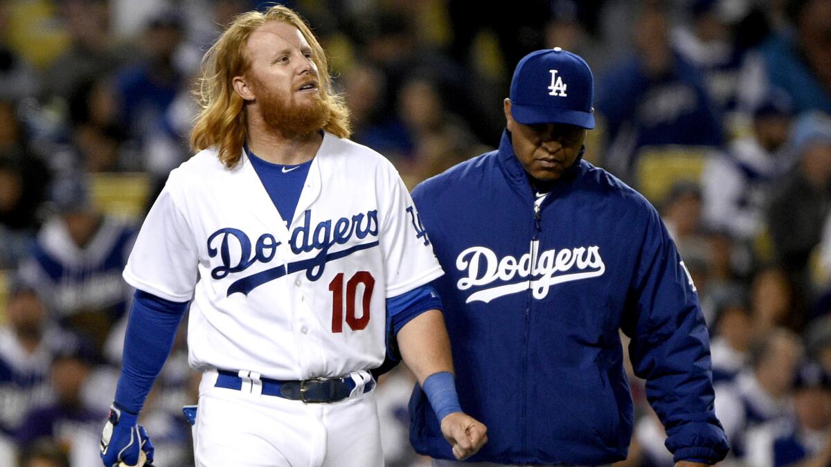 Dodgers Manager Dave Roberts checks on third baseman Justin Turner (10) after he was hit by a pitch during the seventh inning Wednesday.
