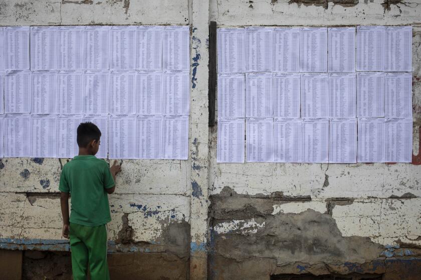 A child plays with electoral roll sheets posted on a wall during municipal elections, in Managua, Nicaragua, Sunday, Nov. 6, 2022. After the Inter-American Commission on Human Rights expressed concern that "the minimum conditions necessary" to hold free and fair elections do not exist in Nicaragua, President Daniel Ortega's Sandinista National Liberation Front is hoping to expand on the 141 of the country's 153 municipalities that it already controls. (AP Photo)