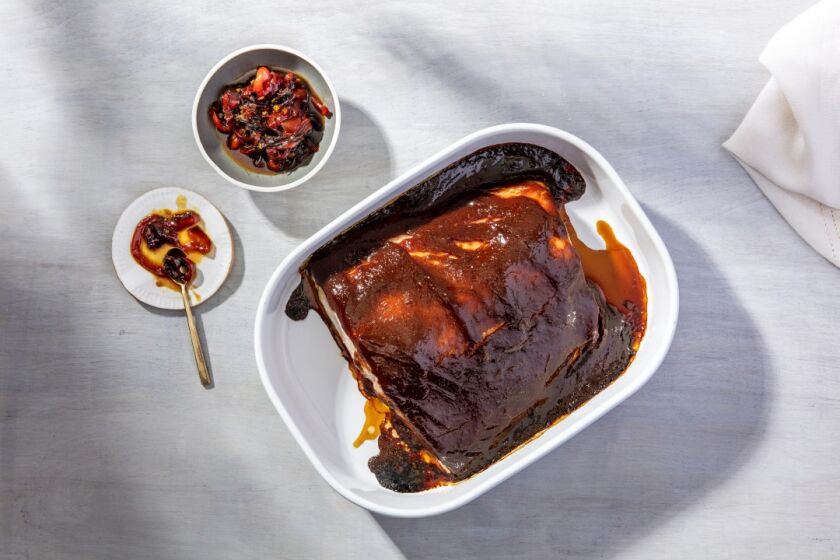 Homemade barbecue sauce, here flavored with umami-rich red miso, is slathered on a slow-roasted side of salmon, shot here with the side of Sweet and Sour Peppers. Prop styling Rebecca Buenik.