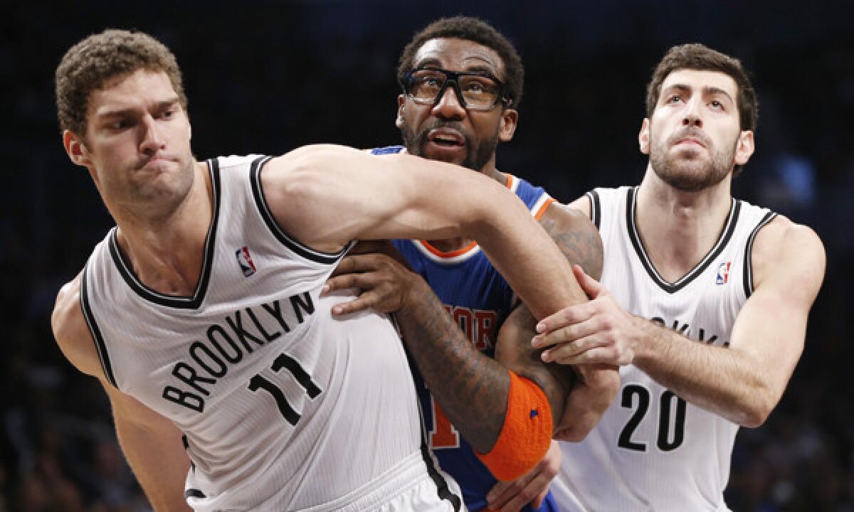 Brooklyn Nets teammates Brook Lopez, left, and Tornike Shengelia, right, defend against Knicks forward Amar'e Stoudemire during a 113-83 New York win on Dec. 5. The two teams renew their cross-town rivalry Monday.