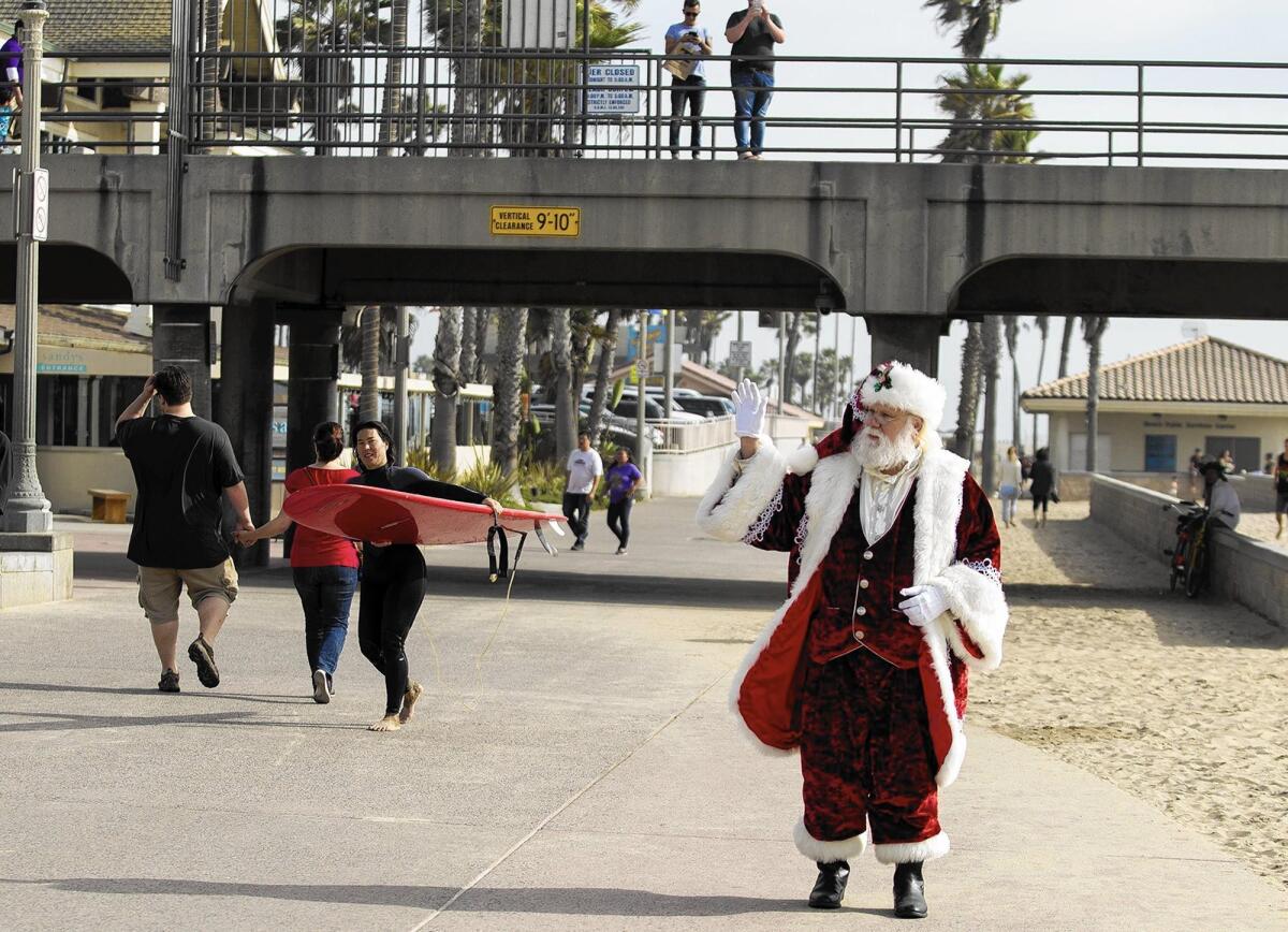 Greg Ferguson, a member of the Orange County Chapter of Real Bearded Santas, walks near the Huntington Beach Pier.